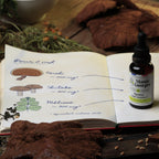 Carnet de Mamie Georges ouvert : pour 2 mL, reishi 500 mg, shiitake 300 mg, mélisse 300 mg, avec le flacon Apaise ton ventre ! posé sur la page